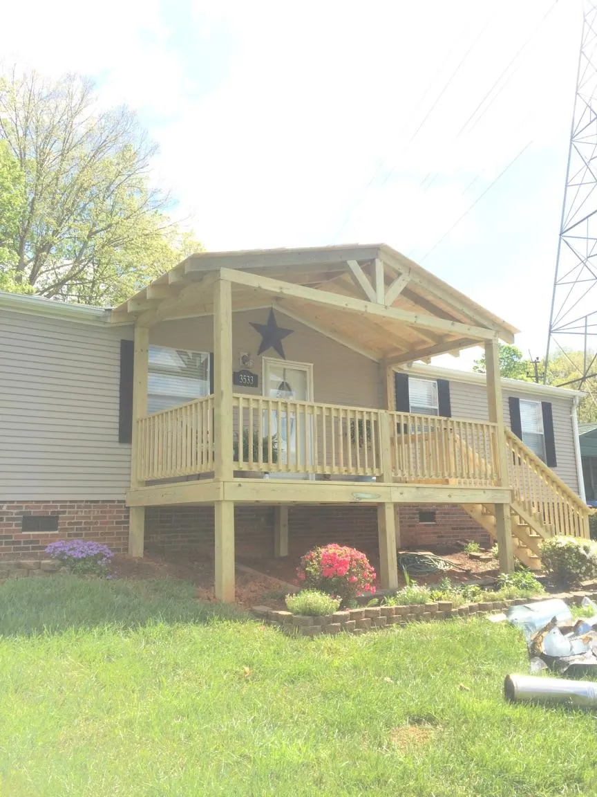 New gabled porch roof and deck railing added to a ranch home in Hancock